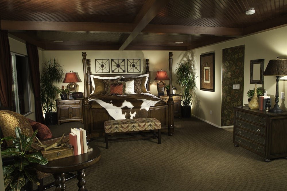宽敞的主卧室，深灰色地毯地板和丰富的木质天花板，外露横梁。