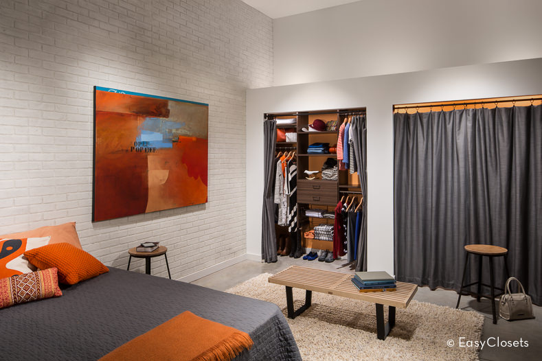 小卧室壁橱设有棕色橱柜和灰色窗帘。
