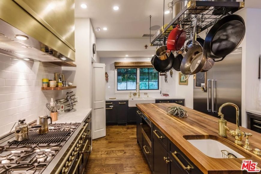 u型厨房有一个大的中央岛台，设有硬木台面。硬木地板和厨房的风格搭配起来很漂亮。