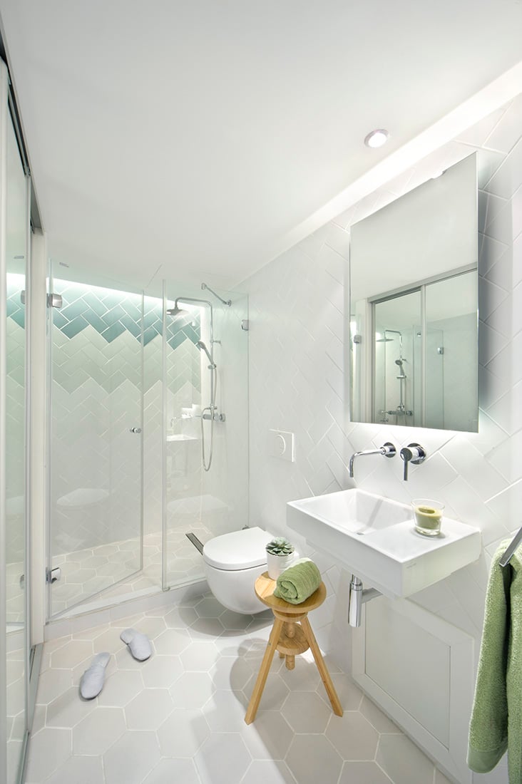 古雅的和简单的无缝融合在这个简单但整洁舒适的浴室。透明玻璃镶板包含的慷慨的大小的走在淋浴和浅灰色六角形瓷砖地板上添加了一个生动的细节。