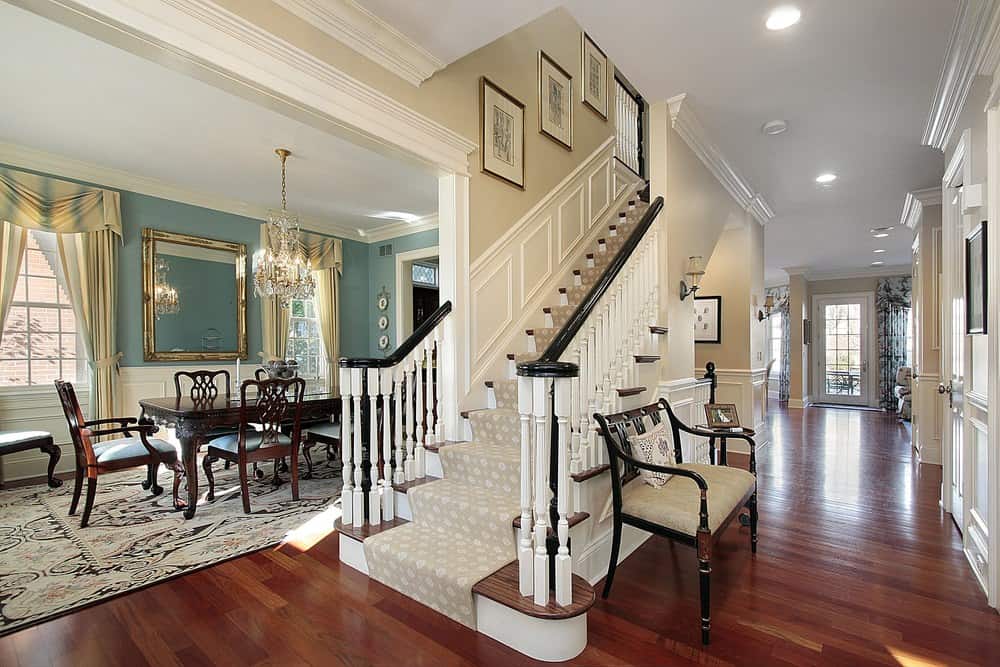 这个家有一个直楼梯，可爱的地毯地板，白色的栏杆和三个墙壁装饰。