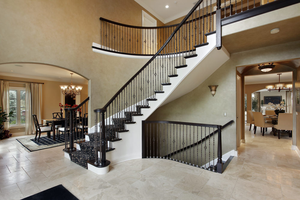 弧形楼梯配有黑色栏杆和时尚的地毯地板。