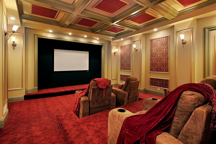 这个家庭影院拥有优雅的红色和金色天花板，与墙壁和地板相匹配。壁灯和嵌入式照明看起来非常优雅。