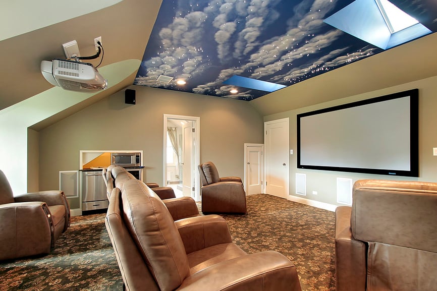 这个家庭影院拥有优雅的地毯地板和非常令人惊叹的天花板，以及棕色皮革组合影院座椅。
