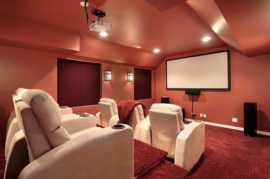 这个家庭影院拥有时尚的天花板和红色的经典地毯地板。