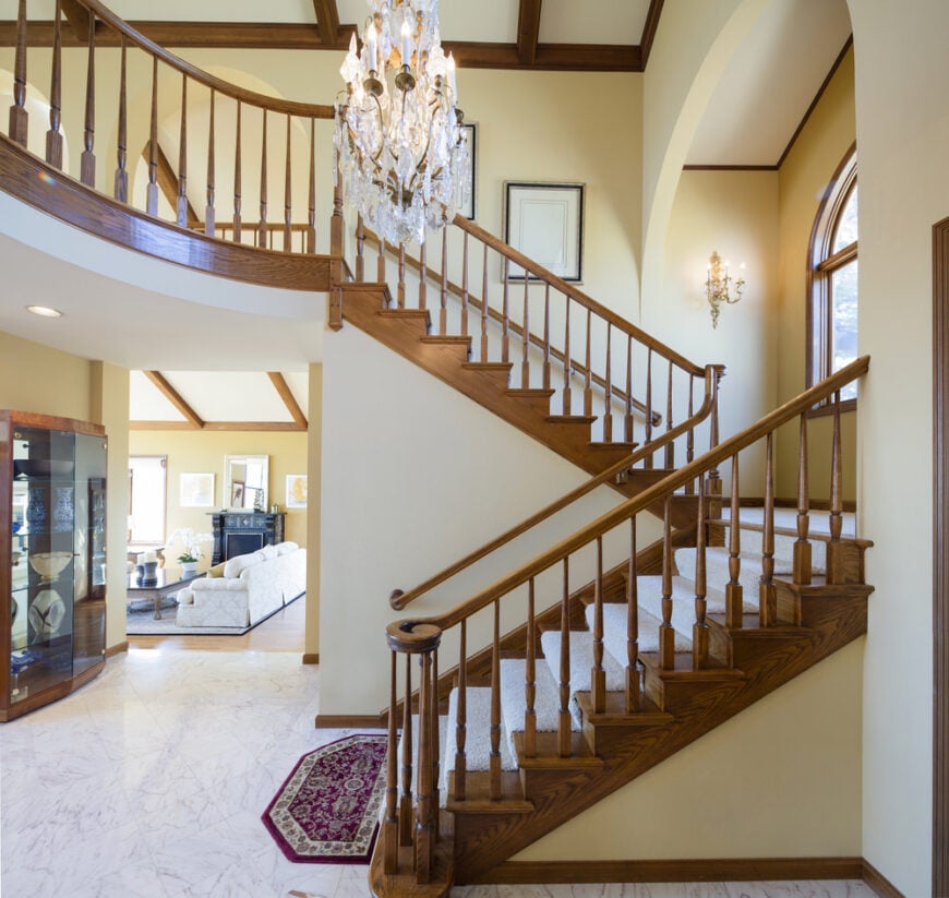 深棕色的木质楼梯踏板和扶手与白色地毯形成了鲜明的对比。