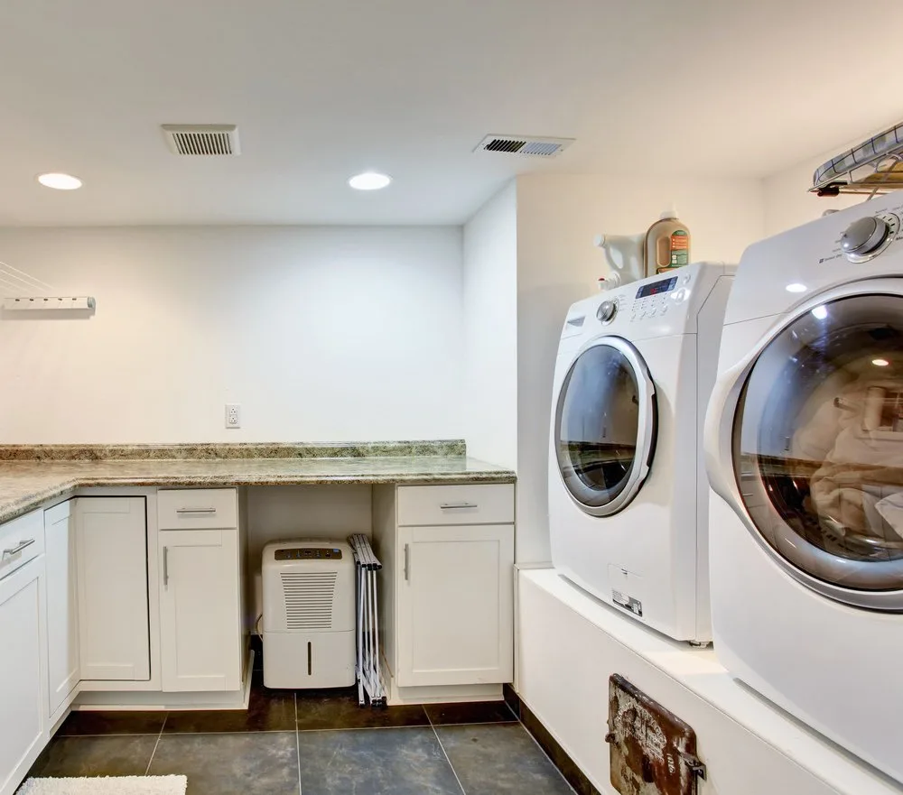 洗衣房特性提高洗衣机和干衣机,大理石台面,瓷砖地板和橱柜进行存储。