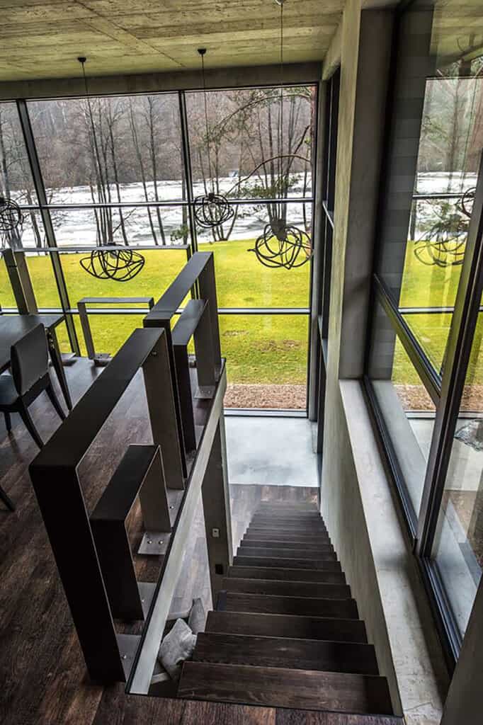 这座质朴的房子以通高的玻璃和带有深色木踏板和独特金属扶手的直楼梯为特色。