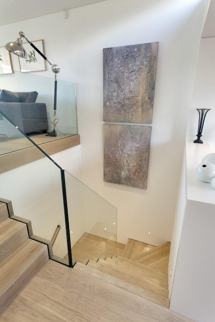 木制楼梯平台上的无框玻璃扶手。一个极简主义、现代的开放空间是个好主意。