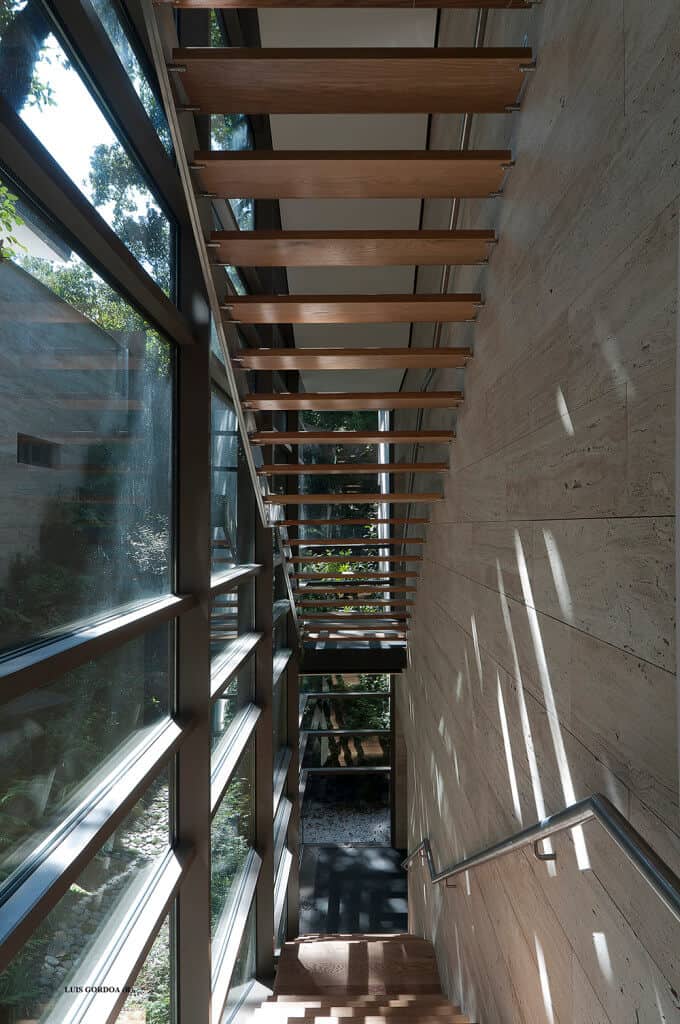 现代木制直窄楼梯和楼梯平台与钢扶手。