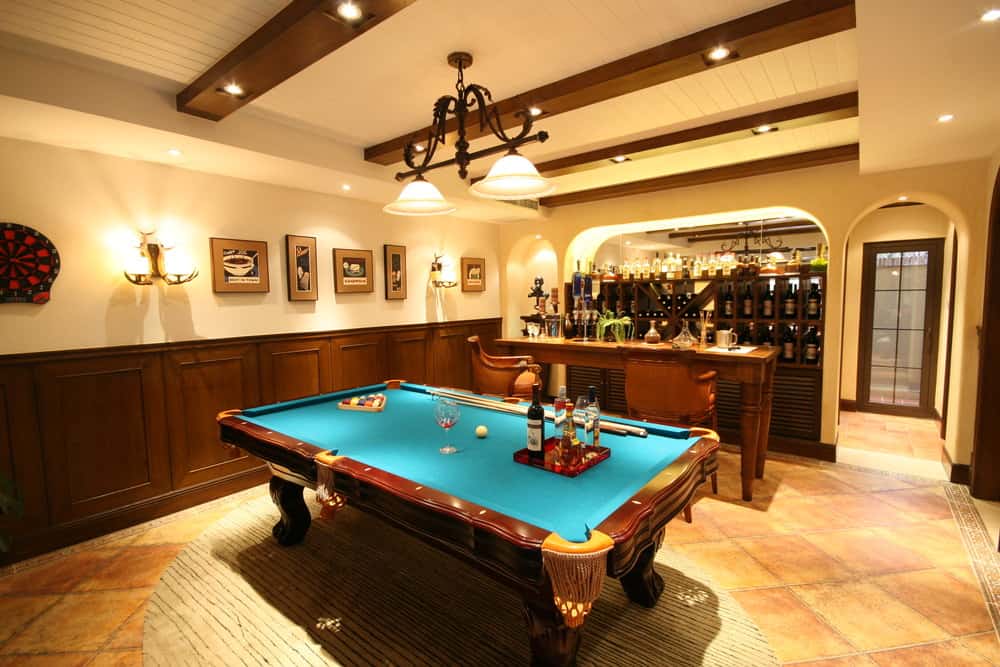 这个男人洞穴的特点是一个优雅的酒吧区，时尚的酒窖和台球池设置在瓷砖地板上的地毯上。