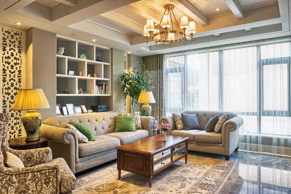 优雅的正式客厅，有一个小吊灯和舒适的座椅，还有一个优雅的地毯。