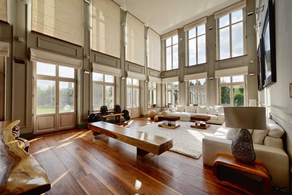 大型正式客厅，高耸的天花板和质朴的地板，以及时尚的家具和地毯。