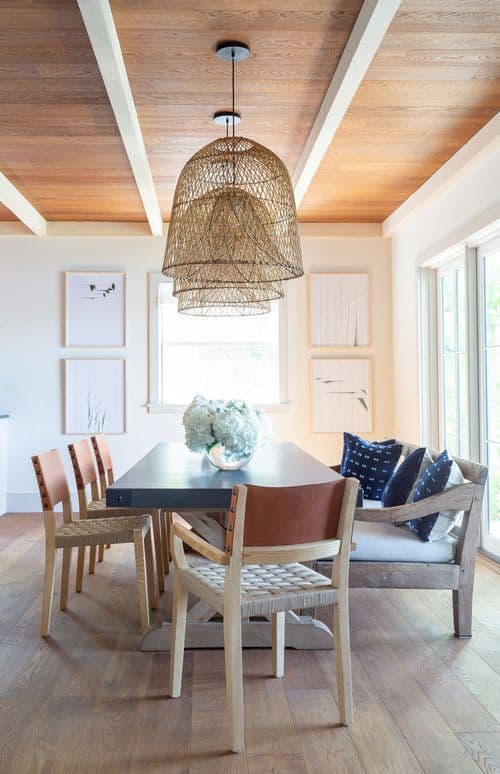 这间温馨温馨的餐厅铺有硬木地板，与质朴的木椅和木制软垫长椅相映成趣，木桌周围环绕着质朴编织帽上的吊灯。