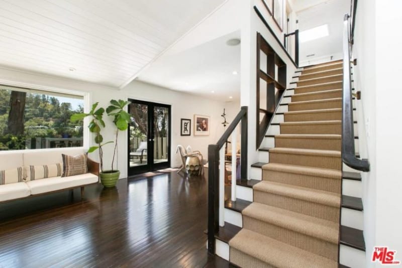 全新的开放式平面住宅提供了玻璃入口和深色硬木地板，与米色地毯覆盖的楼梯踏板相辅相成。