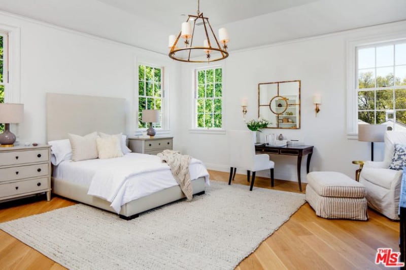 质朴的吊灯，梳妆台，轻木地板和舒适别致的家具完美地补充了这个白色的客卧。