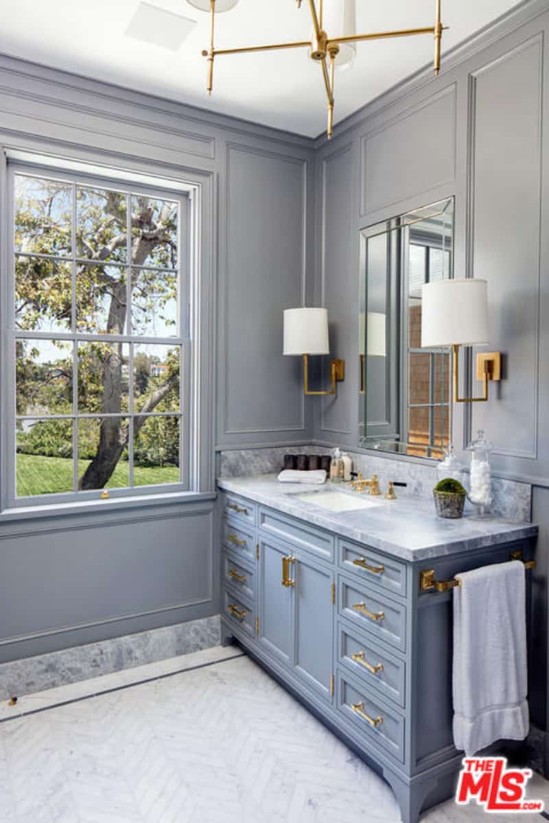 灰色的阴影很适合这个优雅的浴室林赛。整个设计看起来令人耳目一新，木墙与锯齿形瓷砖非常匹配。黄铜照明装置和一扇巨大的双挂窗突出了这个房间。
