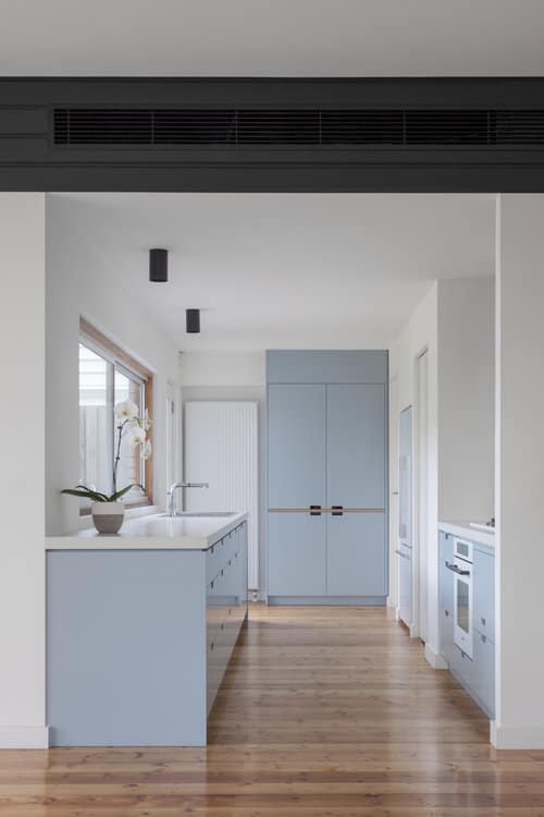 这个厨房拥有浅蓝色的橱柜和硬木地板上的厨房柜台。颜色的组合是如此迷人。