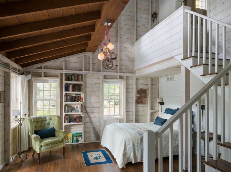 这间主卧室拥有木质天花板和木质墙壁，以及硬木地板。它有一个通往浴室的楼梯。