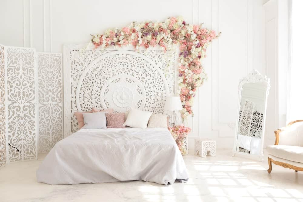 这个主卧室可爱的床设置被白色的墙壁和白色的装饰包围，使房间如此明亮。