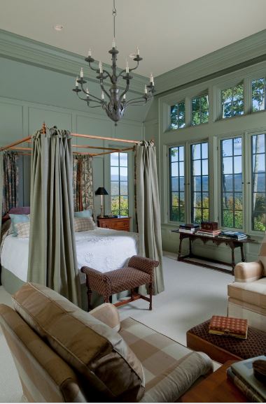 高墙的绿色色调与这间主卧室的四柱床的窗帘相匹配，深绿色的枝形吊灯与之相辅相成。