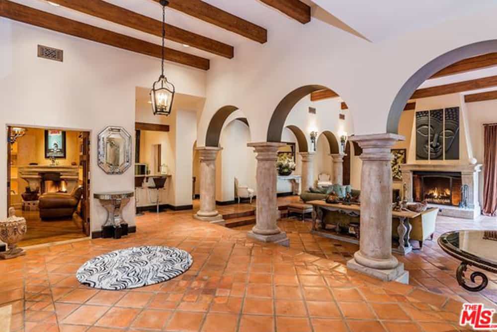 这个门厅拥有陶土瓷砖地板和围绕客厅的开放式拱门。它包括一个与八角形镜子配对的镜像控制台。