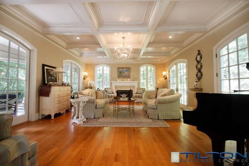 传统设计的客厅上方的白色方形方格天花板被红色的硬木地板所温暖。