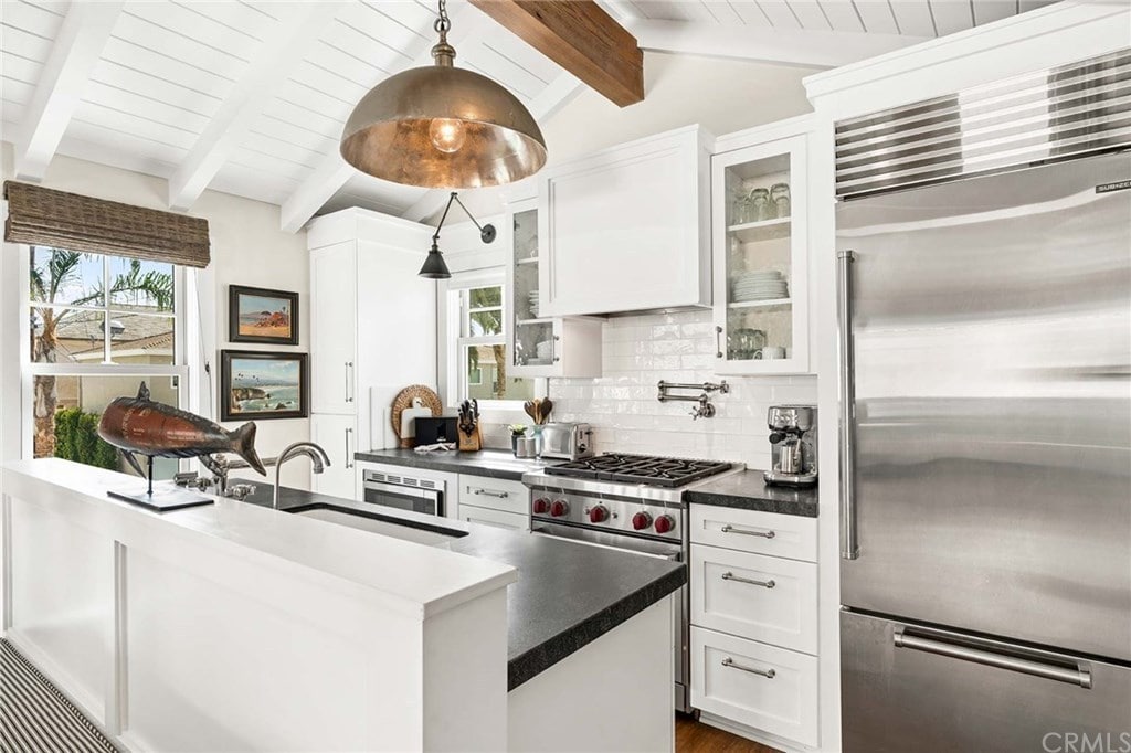 这间厨房提供质朴的白色墙壁和大木梁形成对比的吊顶。它配备了不锈钢用具和一个安装在厨房吧台上的下置水槽，由一个超大的铜吊坠照明。