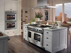 厨房岛台，配有烤箱和配套的灶具和罩。