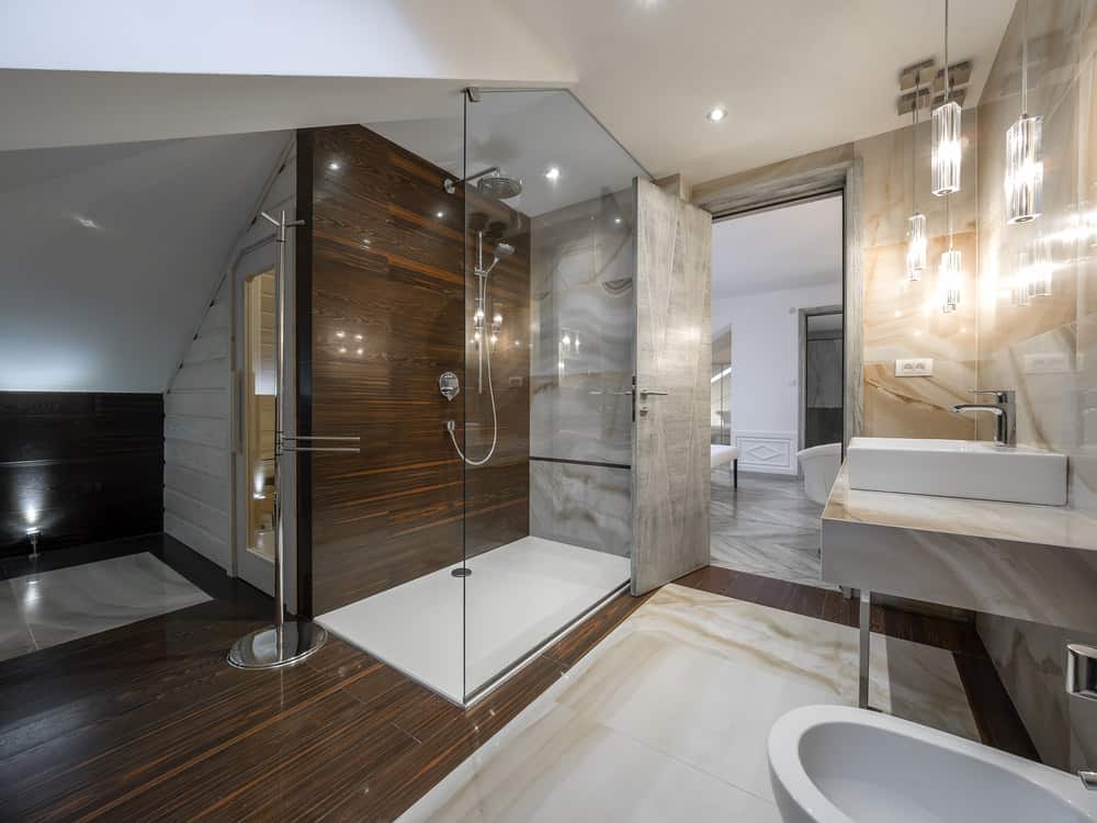 豪华现代的主浴室浏览淋浴和深色的木地板。