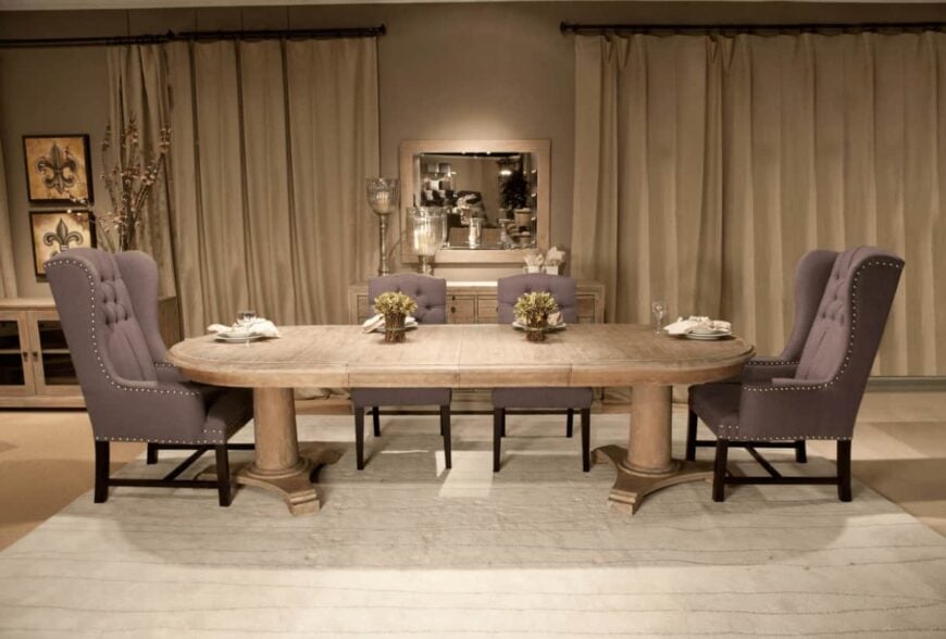 传统的餐厅有米色的簇绒椅子和椭圆形的餐桌，与木制的自助餐桌搭配镜子。