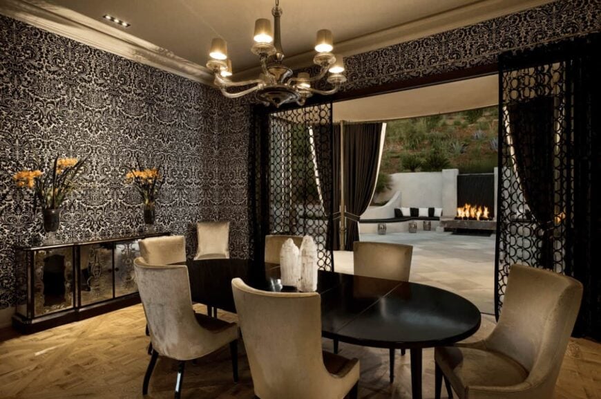 在经典的黑色壁纸，这个餐厅设有一个优雅的餐厅设置和镜面自助餐桌上的玻璃花瓶。吊灯的环境光给房间带来了舒适和浪漫的氛围。