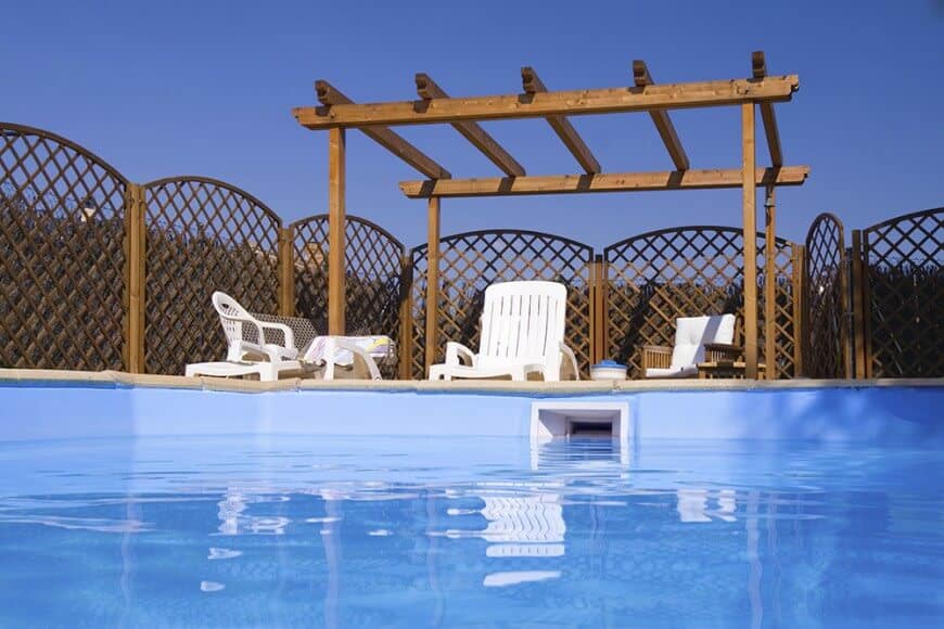泳池边的藤架与木栅栏的装饰相匹配，形成了游泳池周围统一的外观。