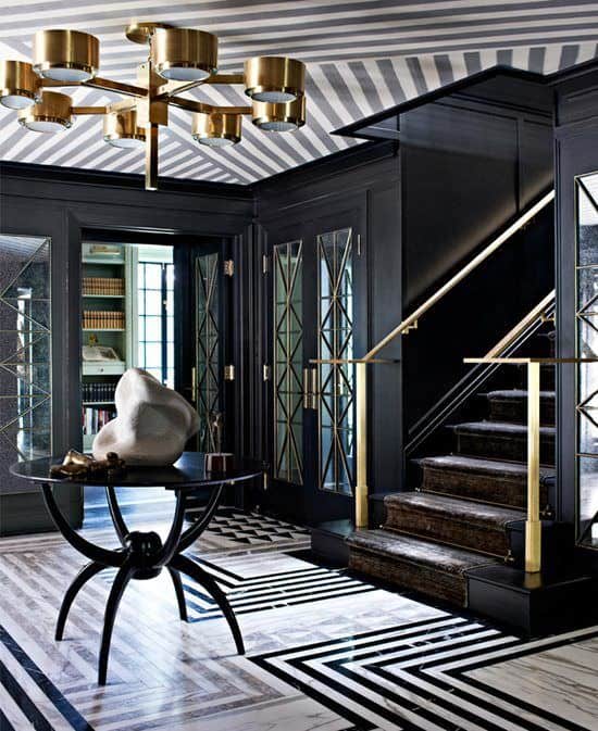 经典的黑色门厅与配套的地板和天花板。门看起来很优雅，而楼梯的金色栏杆绝对令人惊叹。
