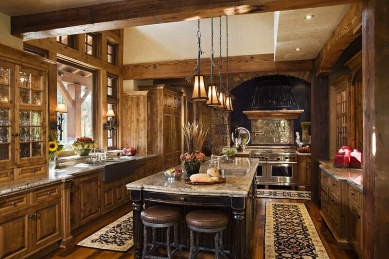 非常古典的厨房，四周都是木制的细节。中间的桌子看起来很迷人，有一个小的早餐吧台，由令人惊叹的吊灯照亮。
