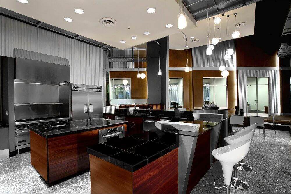 这个阴暗的厨房拥有时尚的灰色地板，黑色的台面遍布整个厨房。半岛看起来如此美丽迷人。