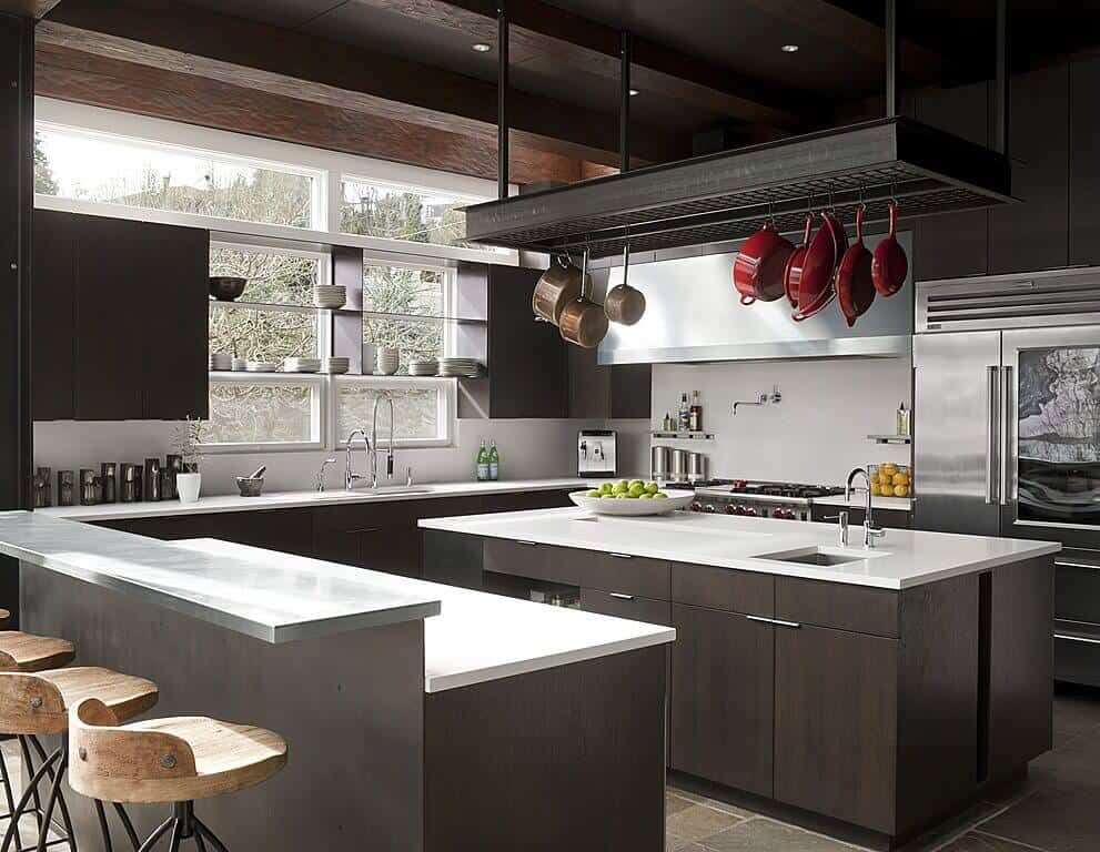 这间厨房拥有深色的装饰细节，光滑的白色台面遍布整个厨房。