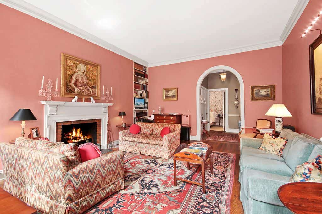 大的传统客厅，粉红色的墙壁，拱形的门口和砖砌的壁炉。