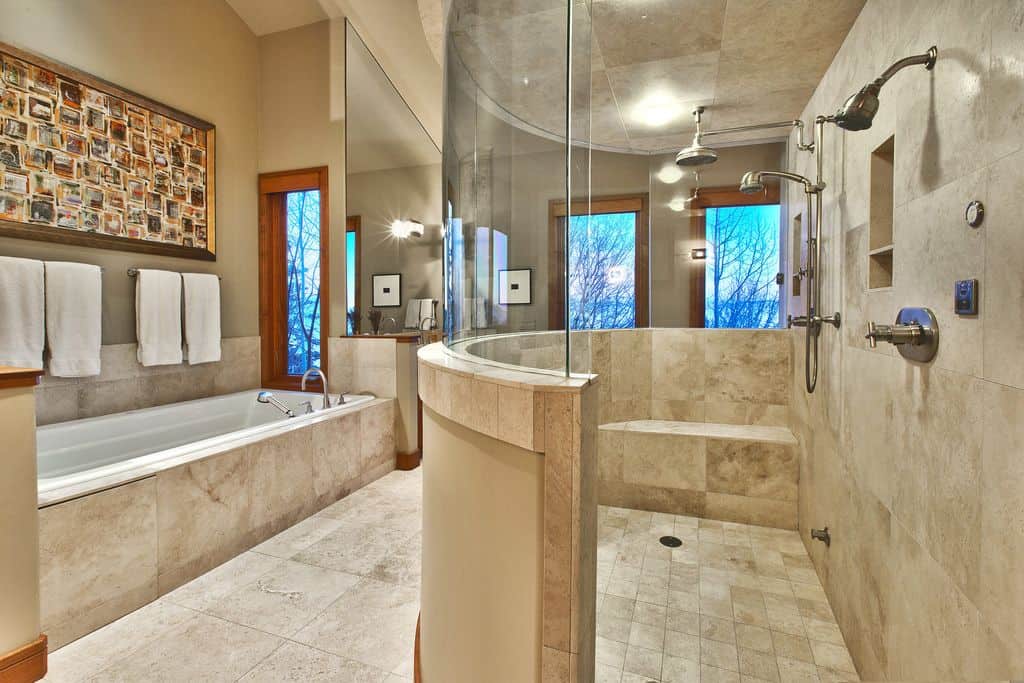 传统的主浴室设有一个巨大的步入式淋浴和超大型的浸入式浴缸，墙壁和地板上都铺着大理石瓷砖。