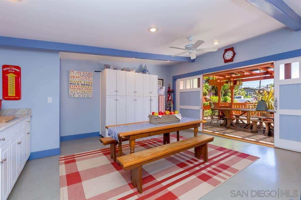 这个工匠风格餐厅的色彩和活力增加了温暖的品质。墙壁和天花板被赋予了蓝色的色调，使白色的天花板和白色的格子地毯突出。这也影响了木桌和旁边的长凳。
