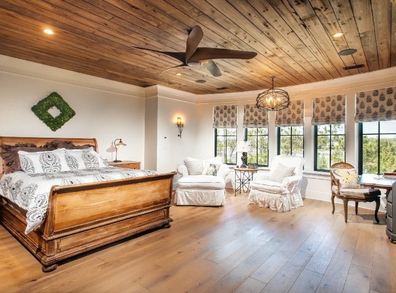 这间主卧室拥有与硬木地板相匹配的木质天花板。房间里还有一张乡村风格的舒适床。旁边还有一个休息区。