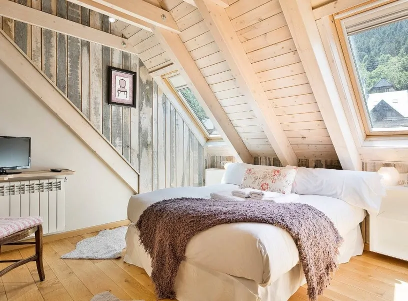 这主要集中在卧室舒适的白色床上包围木制墙壁和天花板,实木地板。