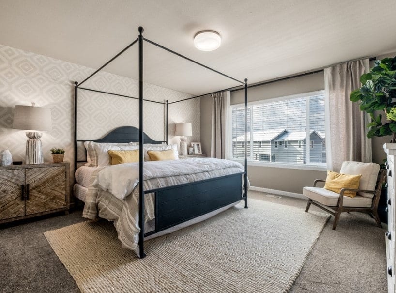 主卧室设有一个由两盏台灯照亮的优雅的床，墙壁设计看起来也很时尚。房间还铺有灰色地毯。