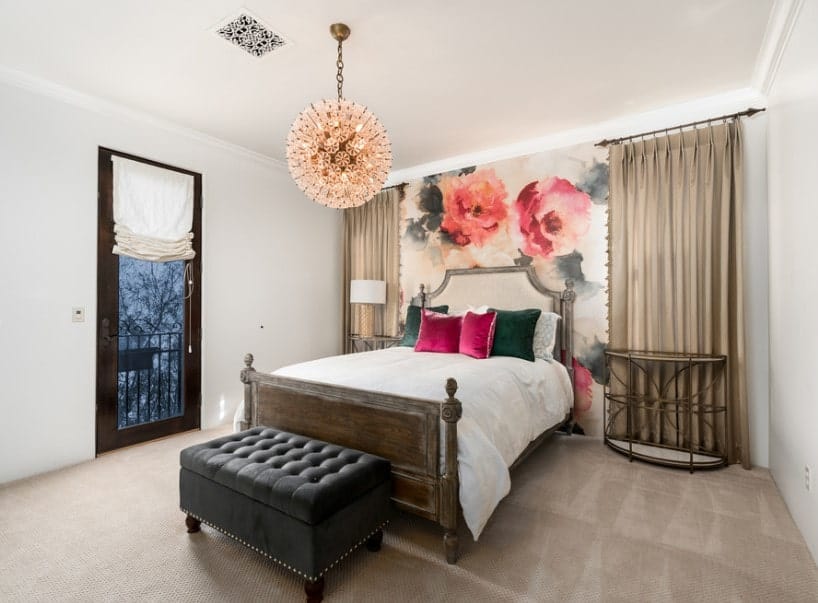 主卧室拥有地毯地板和美丽的墙壁设计。它提供了一个漂亮的床设置由一个花哨的吊灯。