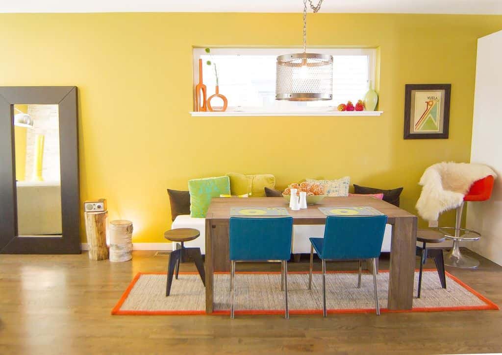 小型不拘一格的黄色餐厅，内置书架，长凳和硬木地板与地毯。