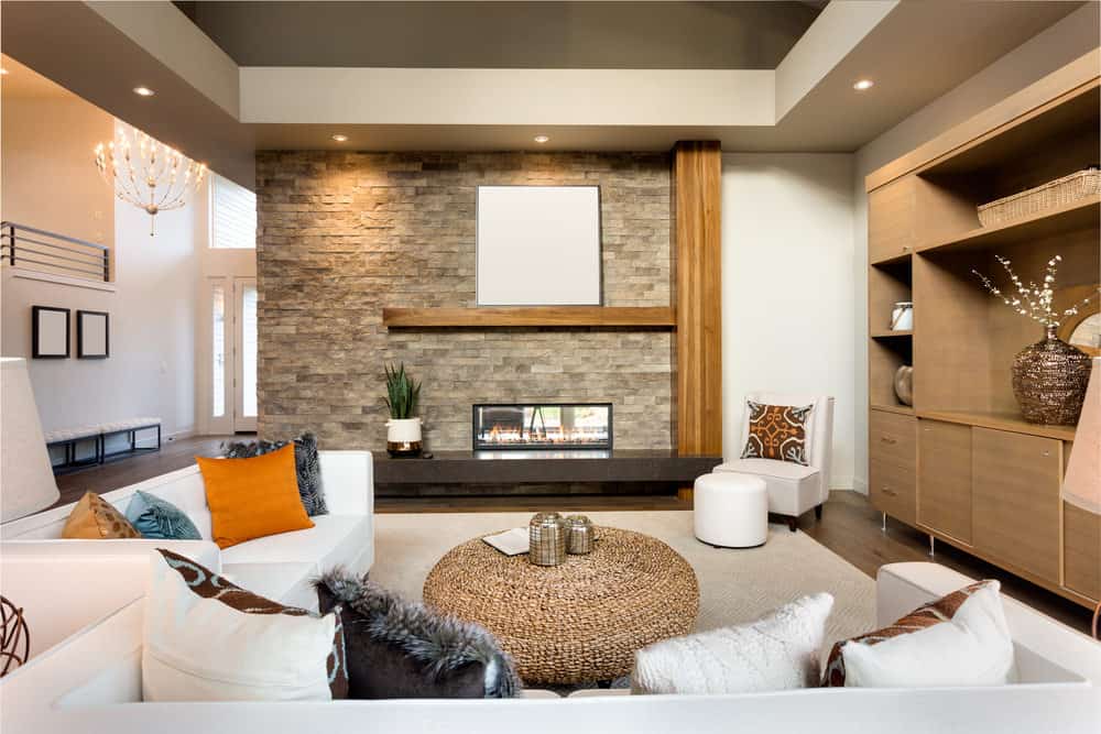 大正式客厅以白色沙发上设置一套漂亮的地毯在硬木地板上。有一个流行的壁炉也看起来非常有吸引力。
