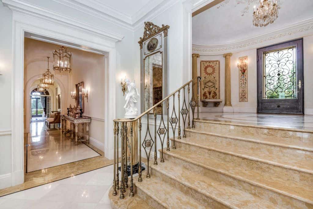 一个优雅的家庭的入口，一个短楼梯通往家庭的迷人的走廊，由美丽的吊灯照亮。
