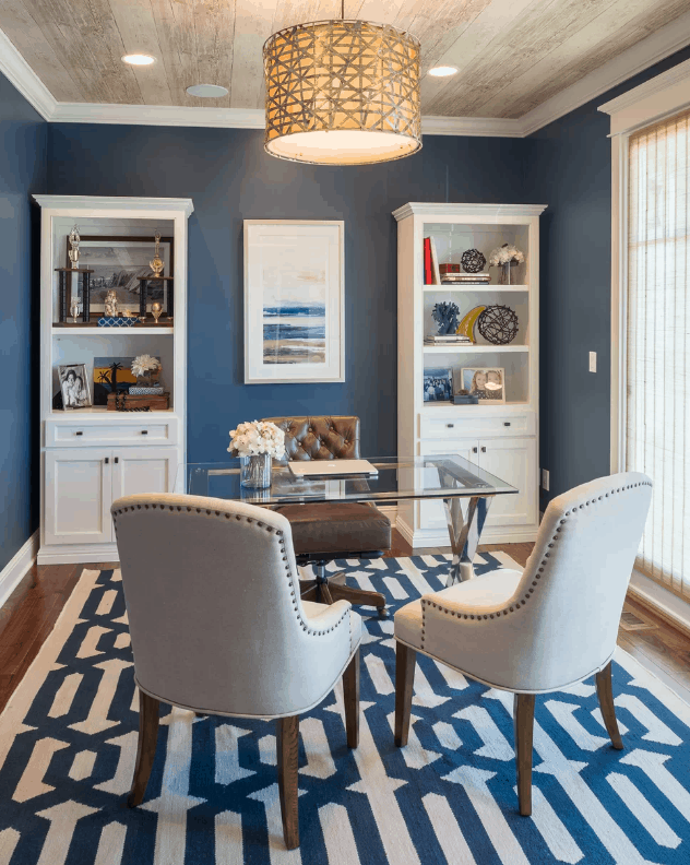 传统的家庭办公室，有蓝色的墙壁和地毯，在木制的常规天花板上有漂亮的吊灯。