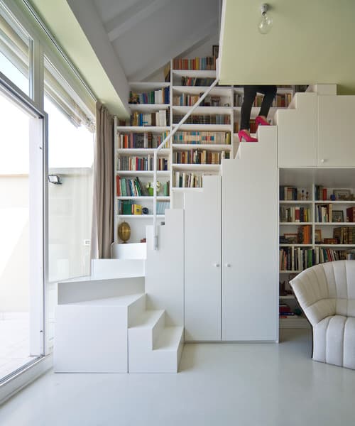 带有薄扶手的现代白色楼梯，内置存储空间和书架。