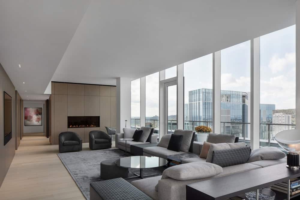 现代客厅，时尚的沙发和地毯，玻璃窗和白色的常规天花板。